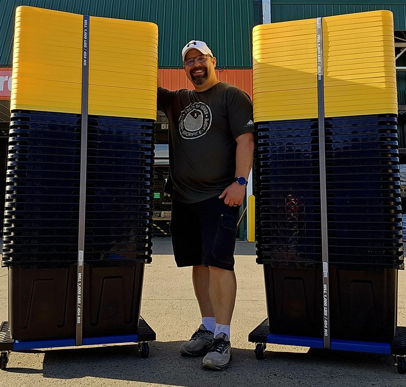 Tori standing between two full columns of moving totes strapped to Tote Carts